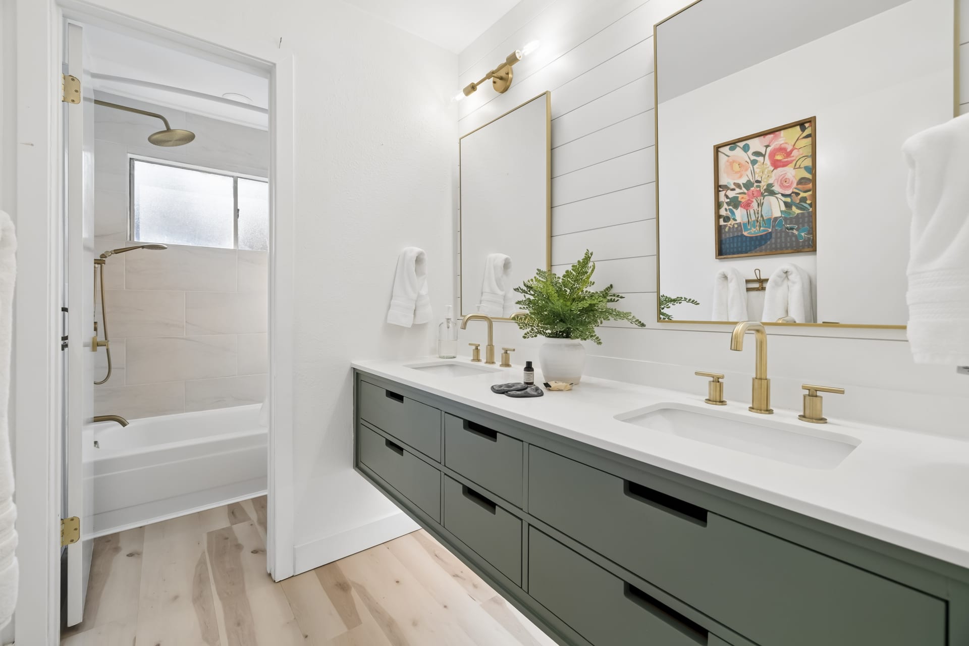 Contemporary spa bathroom vanity with illuminated mirror and brass hardware